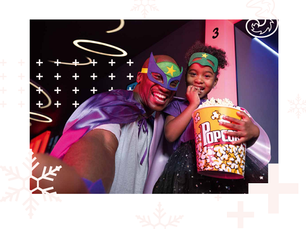 A man and daughter with a large popcorn dressed like superheros